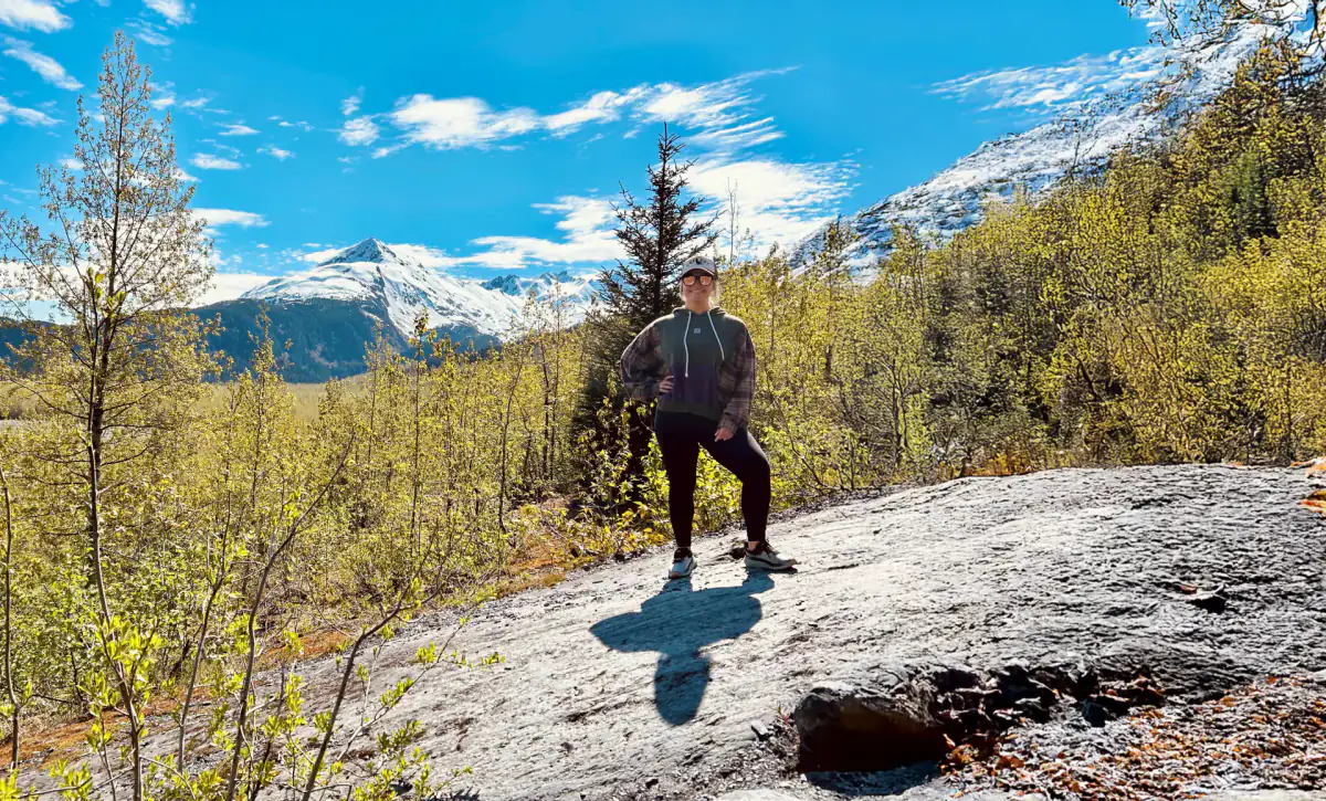 Jordan Sackett standing on a rocky trail in the Alaska mountains